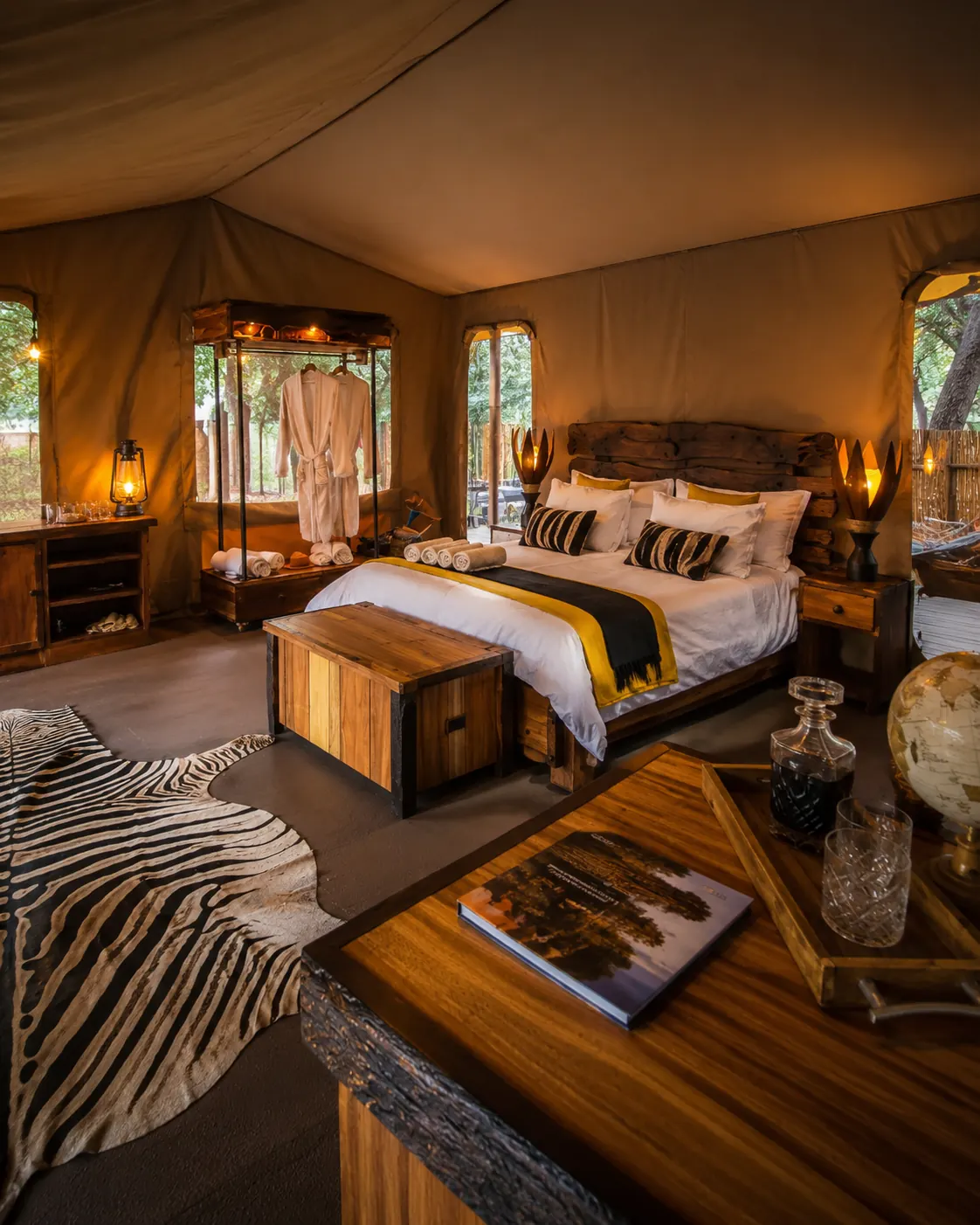 Classic safari tent bedroom with timber chest, hide rug and warm lantern light