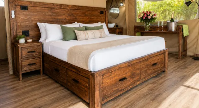 King bed with solid timber headboard and storage drawers in a safari tent