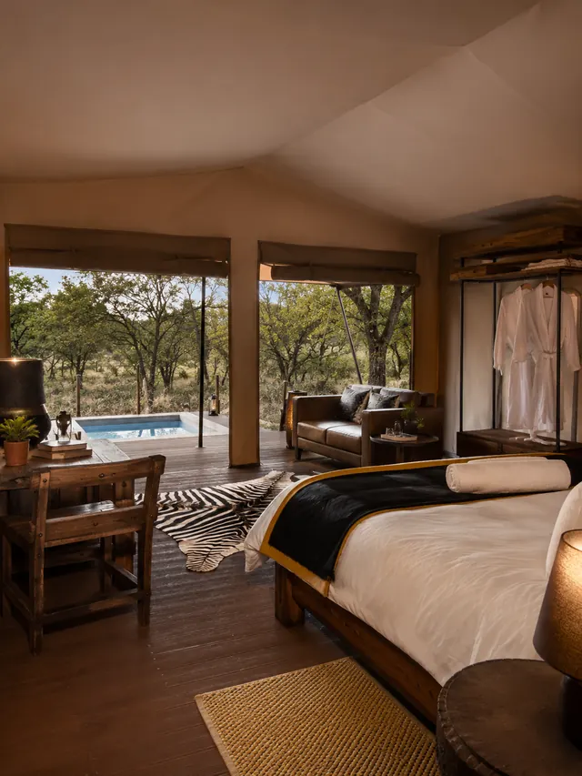 View from a safari tent interior across the deck to a plunge pool